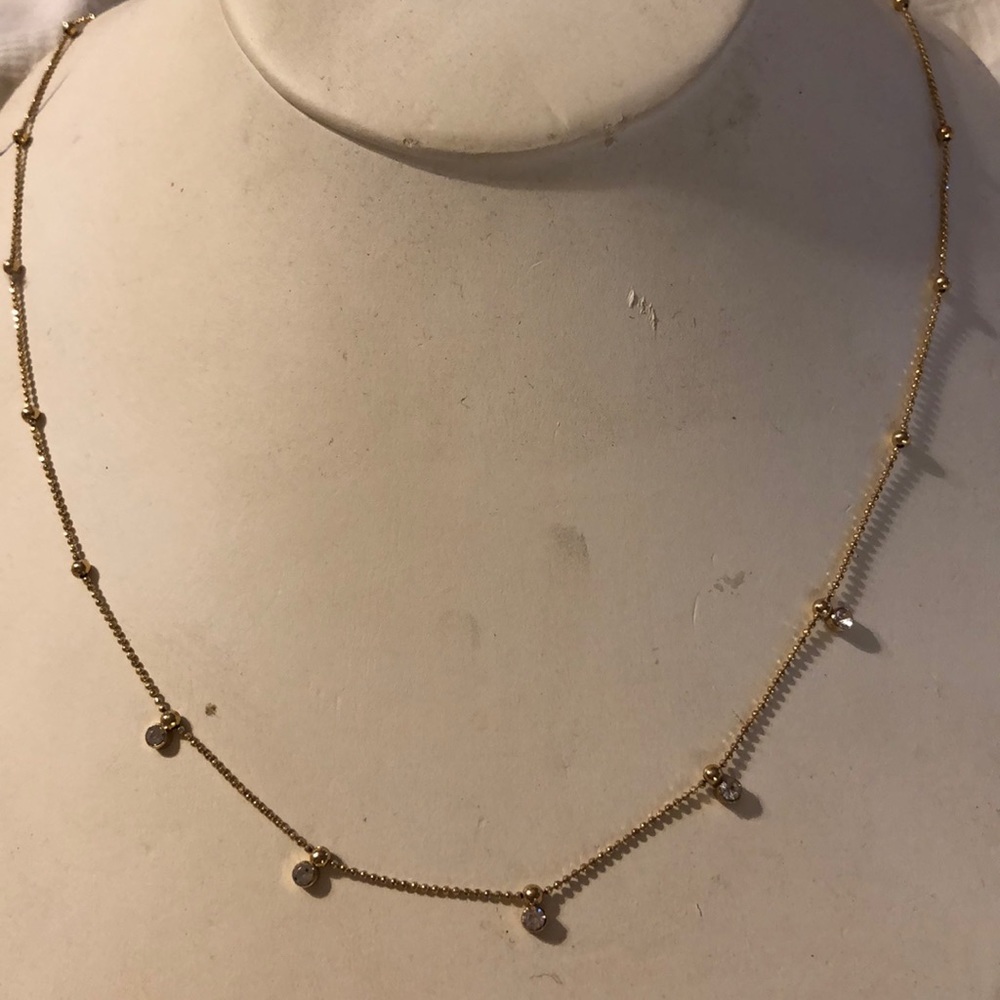 Gold colored necklace with rhinestones.